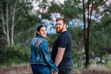 happy young married couple holding hands while on a walk through bushland