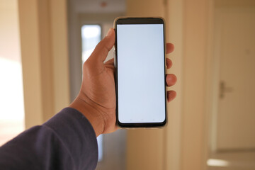 close-up hand using phone showing white screen in empty room