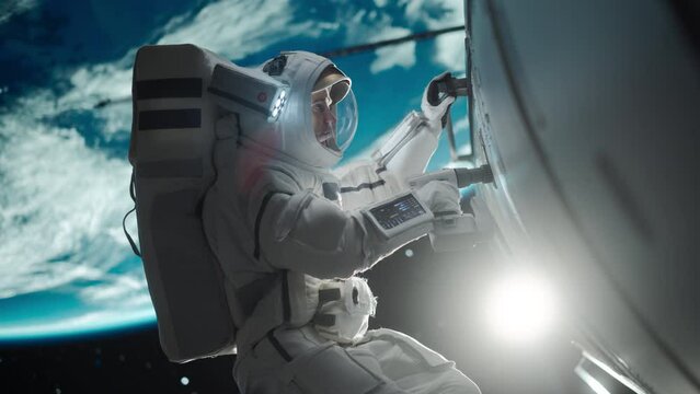 Space Technician Mending a Panel on an International Space Station with an Automatic Screw Gun. Fearless Astronaut Working in Outer Space with Gorgeous Blue Planet in the Background