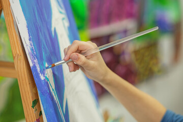 Artist's Hand Painting Broad Strokes on Canvas
