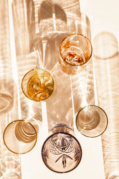 Warm orange light on glasses and cups throwing patterned shadows