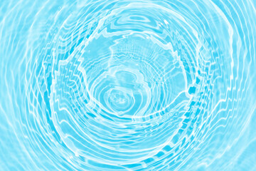 Water surface. Bluewater waves on the surface ripples blurred. Defocus blurred transparent blue colored clear calm water surface texture with splash and bubbles. Water waves with shining pattern.