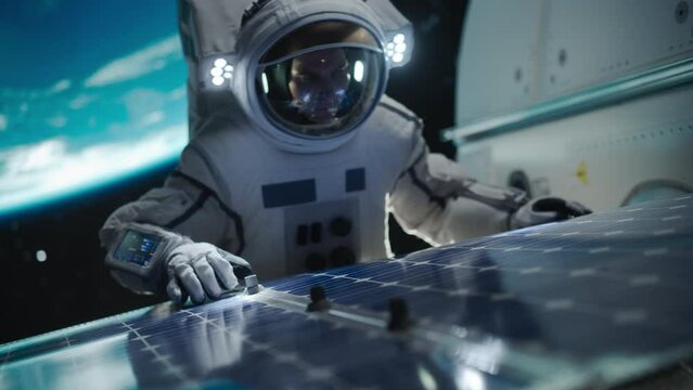 Astronaut on an Extravehicular Mission in Outer Space Far From Planet Earth. Courageous Man Fixing and Adjusting the Angle on a Solar Panel Module Outside the Space Station During a Service Procedure