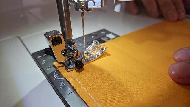 Patchwork quilt creation process - closeup of the sewing needle in slow motion.