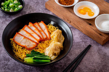 Egg noodle with red roasted pork and wonton in black bowl