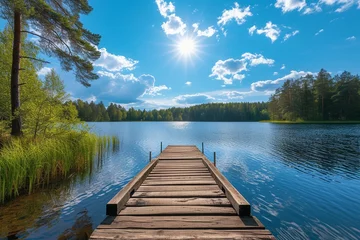 Foto auf Leinwand Traditional Finnish and Scandinavian view. Beautiful lake on a summer day and an old rustic wooden dock or pier in Finland. Sun shining on forest and woods in blue sky. © Areesha