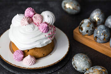 Beautiful stylish still life. Easter cake with meringue, marshmallows, and Easter eggs on a dark background. happy Easter 2024.
