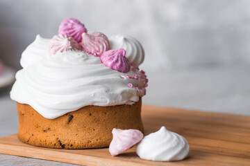 Beautiful stylish still life. Easter cake with meringue, marshmallows, Easter eggs and willow twigs on a light concrete background. happy Easter 2024.