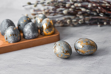 Stylish grey Easter eggs made of marble and concrete with a golden potala on a grey background. Coloring eggs with natural dye karkade tea. . The concept of a happy Easter.