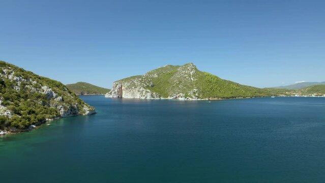 Cinematic upwards moving 4K drone clip over the tropical blue waters of Toroni in Chalkidiki