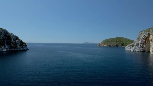 Cinematic backwards moving 4K drone clip over the tropical blue waters of Toroni in Chalkidiki