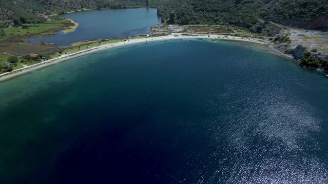 Cinematic forward moving 4K drone clip over the tropical blue waters of Toroni in Chalkidiki