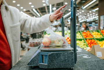 The man's finger selects the desired product in the supermarket on the touch screen of the...