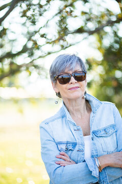portrait of a senior woman in the garden wearing sunglasses