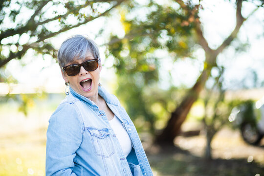 portrait of a senior woman in the garden wearing sunglasses