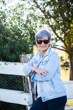 portrait of a senior woman in the garden wearing sunglasses