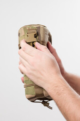 Fototapeta premium A man holds a protective cover for a monocular, pixelated fabric for the military.