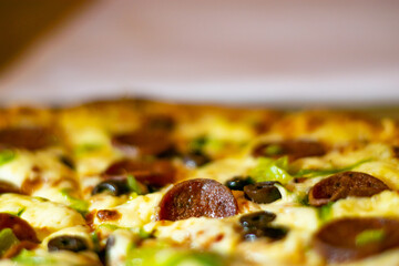 Close up shots of a delicious pepperoni pizza with Mozzarella cheese, salami, pepper, and fresh olives  Italian pizza