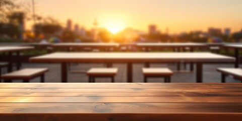 Blurry sunset behind empty wooden table top. Summer evening banner with copy space. In-focus empty bar counter.