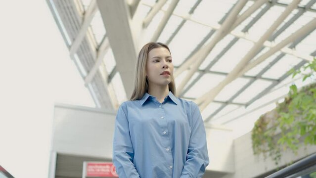 Caucasian or brunette white woman with brown hair holding paper bag walking and shopping in the shopping mall or department store.