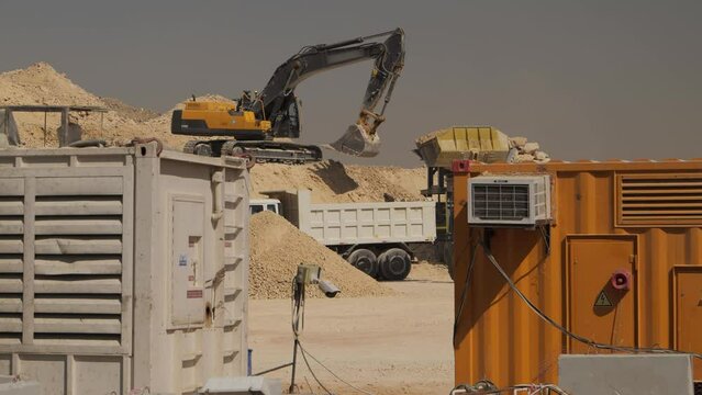 Excavator Loads Dump Truck at Construction Site