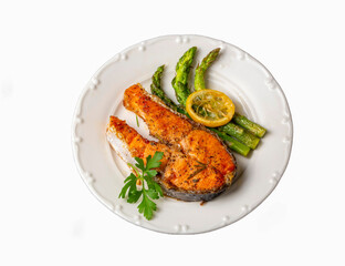 Grilled, baked salmon served on a plate with asparagus and potatoes