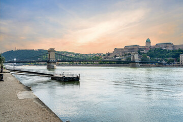 Szechenyi Chain bridge over the Danube River in the city of Budapest. Urban landscape with old buildings, St. Stephen's Basilica and opera domes. Hungary.