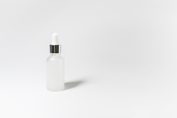 a glass bottle with cosmetic serum on a white background. skin care concept