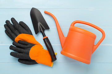 Orange gardening tools on wooden background, top view