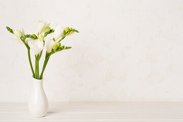 Nice bouquet of white freesia flowers in vase on table