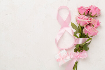 Composition with pink roses, gift box and eight made of ribbon on concrete background, top view. Women's day concept