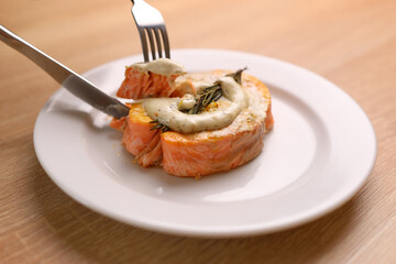 They taste a baked piece of salmon with sauce
