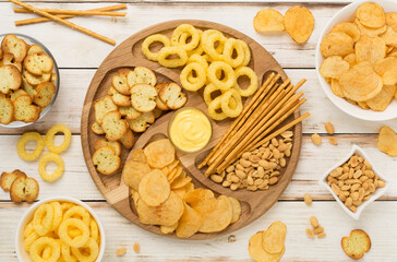 Various unhealthy snacks on wooden background, top view