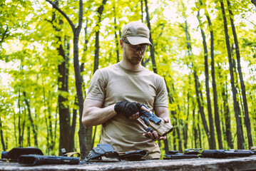 guy in the woods tests his weapons for shooting sports