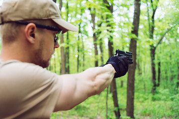 instructor with gun in forest leads aiming and posing on camera