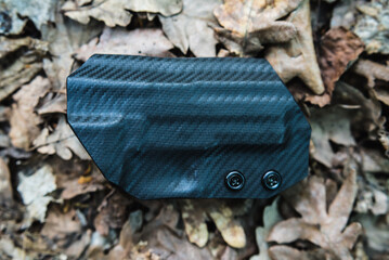 objective holster shooting on dry leaves in the forest