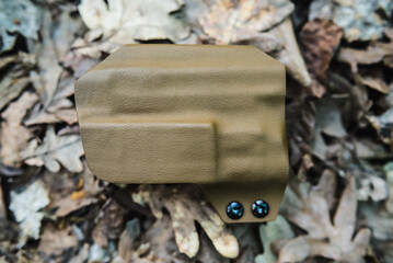 objective holster shooting on dry leaves in the forest