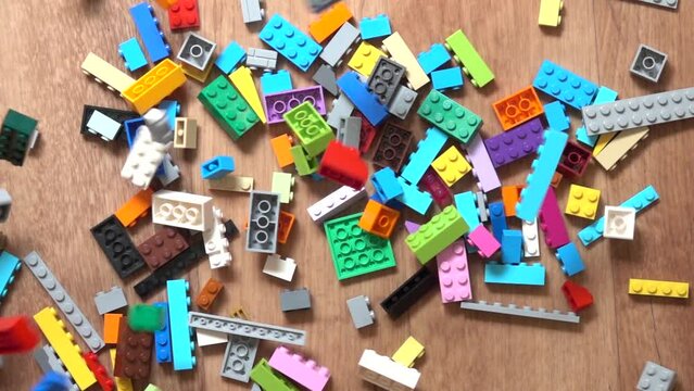 Falling colorful plastic toy bricks in box. Slow motion, Top down view
