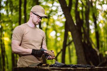 guy in the woods tests his weapons for shooting sports