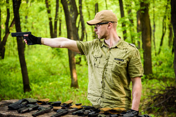 guy in the woods tests his weapons for shooting sports