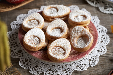 Linzer cookies in the shape of Easter eggs on a red plate, closeup