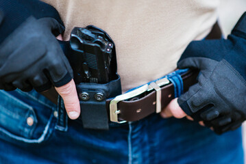 the guy puts the gun in the holster close-up