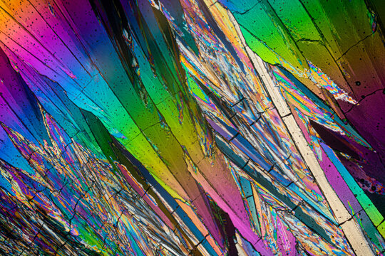 Abstract and colorful micrograph of erythritol sugar crystals, showcasing a spectrum of colors with a dynamic, angular composition