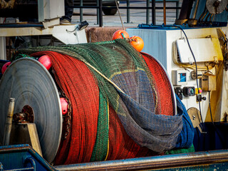 close up view of rolled up fishing net on a winch aboard a small fishing boat