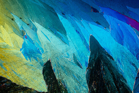 Polarized light microscopy reveals the cool blue and warm yellow hues of erythritol sugar crystals with detailed textures
