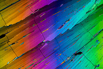 A microscopic landscape of erythritol sugar crystals, featuring a striking diagonal array of rainbow colors
