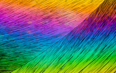 Colorful linear gradients of erythritol sugar crystals viewed under a microscope, resembling vibrant brush strokes
