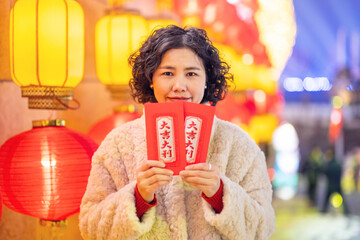 Happy woman holding Chinese New Year red envelope