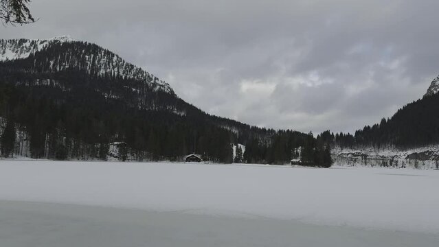 Lake Spitzingsee in winter covered with snow and ice in freezing cloudy weather in Bavaria, Germany. A mountain lake in Bavarian Alps frozen around mountain in Spitzingsee, Schlierseer Berge 