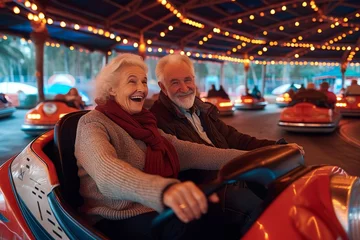 Deurstickers A smiling man and woman sit in a colorful bumper car, their faces illuminated by the indoor lights as they enjoy the thrill of the playful vehicle © Pinklife